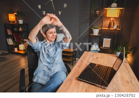 Freelancer woman stretching arms while working from home office Freelancer woman stretching arms while working from home office 130428702