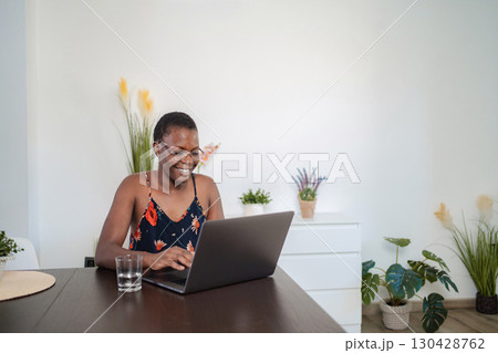 Young black woman working from home typing on a laptop 130428762