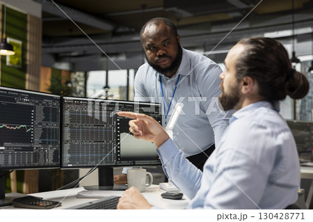 Manager supervising day trader using trading app to capitalize on market fluctuations when buying and selling stocks. Prop firm office team leader and expert identifying profit opportunities 130428771