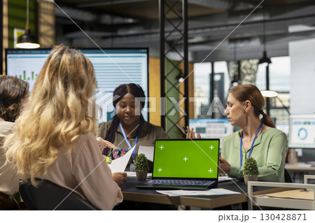 Group of empowered professionals work with green screen on laptop in modern office work environment, embodying a corporate feminism mindset and vision for growth. Empowerment. 130428871