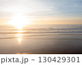 Sunset view of ocean waves reflecting golden light 130429301
