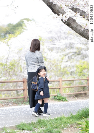 桜と入園式を迎えた3歳の女の子と母親 130429632