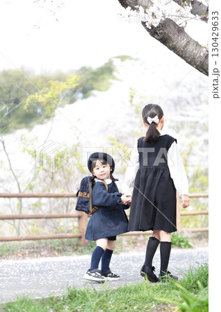 桜と入園式を迎えた3歳の女の子と9歳の姉 130429633