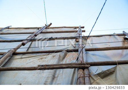 足場丸太を番線で固定して遮蔽シートを掛けた様子 130429833