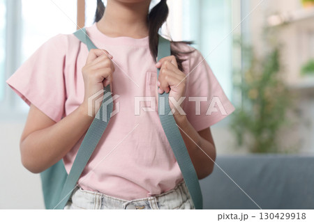 Child adjusting backpack straps before school Child adjusting backpack straps before school 130429918
