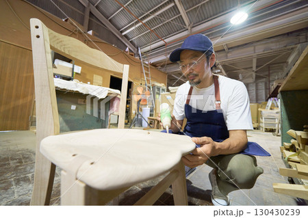 家具製作の組み立て工程で接着作業を行う職人 家具製作の組み立て工程で接着作業を行う職人 130430239