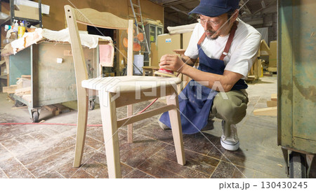 椅子を電動サンダーで仕上げる木工職人 130430245