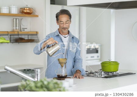 キッチンでコーヒーを淹れる60代の男性 130430286
