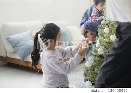 クリスマスツリーを飾る家族 クリスマスツリーを飾る家族 130430433