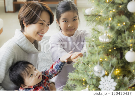 クリスマスツリーを飾る家族 クリスマスツリーを飾る家族 130430437