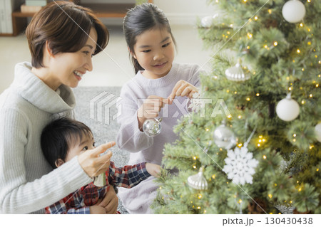 クリスマスツリーを飾る家族　 130430438