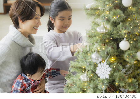 クリスマスツリーを飾る家族　 130430439