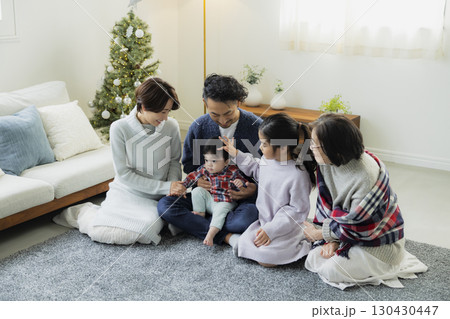 クリスマスツリーを飾る家族　 130430447