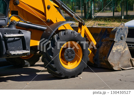 City bulldozer with a large bucket stands on an asphalt road City bulldozer with a large bucket stands on an asphalt road 130430527