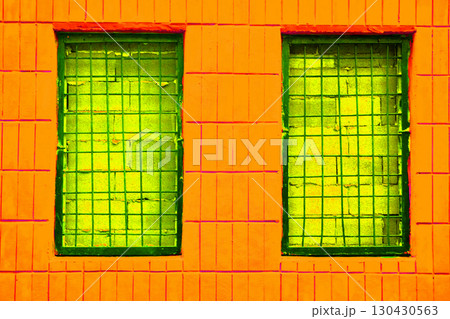 Futuristic fantastic orange tiled wall with shiny green windows with grates Futuristic fantastic orange tiled wall with shiny green windows with grates 130430563