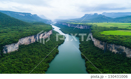 Landscape background Aerial view of lush green river valley surrounded by cliffs and mountains, showcasing beauty of nature and tranquility 130431006