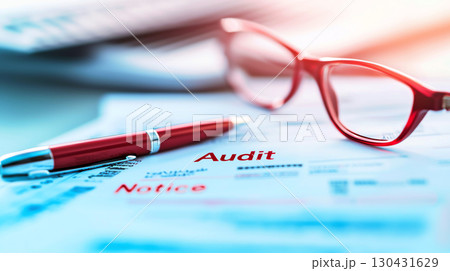red pen and glasses rest on tax forms with audit notice, highlighting financial review and documentation 130431629