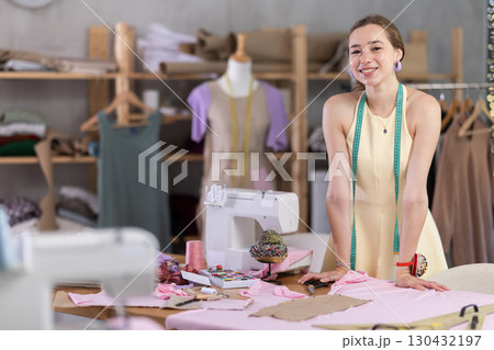 Young woman seamstress invites to sewing workshop Young woman seamstress invites to sewing workshop 130432197