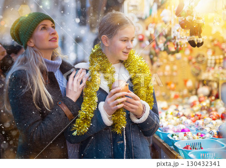 Teenage girl with mother looking for decorations on Christmas street market 130432341