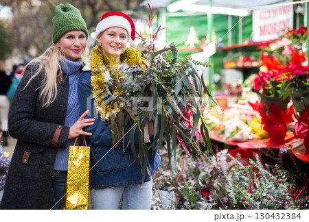Mother and daughter choosing christmas plants 130432384