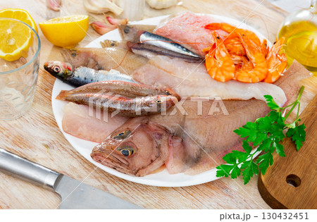Mix of fish with shrimp served on platter 130432451
