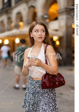 Young woman with phone at Royal Square - Placa Real in Barcelona Young woman with phone at Royal Square - Placa Real in Barcelona 130432468