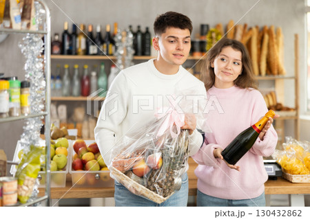 Couple man and woman choosing wine and food gift box 130432862