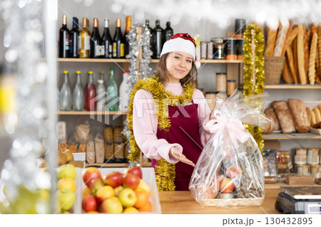 Young female seller offering gift box of food 130432895