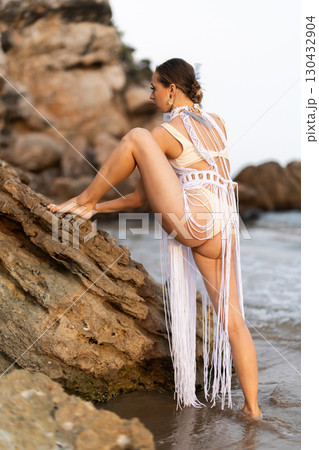Barefoot girl on seashore in sexy and revealing Aztec carnival costume Barefoot girl on seashore in sexy and revealing Aztec carnival costume 130432904