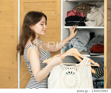 Young woman choosing clothes in closet 130433061