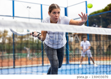 Young female paddle tennis player performing forehand Young female paddle tennis player performing forehand 130433070