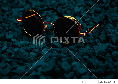 Golden vintage cool gold sunglasses with blue lenses on dark stones 130433214