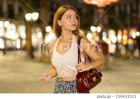 Woman walking around Barcelona, she has visited Placa real and plans to spend the evening in bars and restaurants with friends 130433311