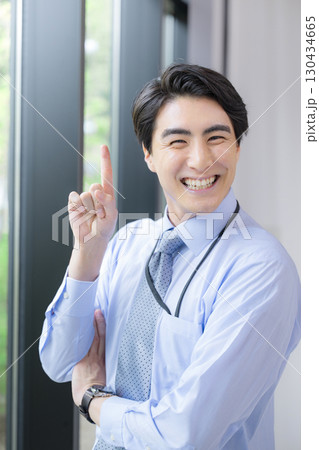 ネクタイとシャツで指差しする若い男性 カメラ目線でポイントの表情 ビジネスシーンの笑顔 ネクタイとシャツで指差しする若い男性 カメラ目線でポイントの表情 ビジネスシーンの笑顔 130434665