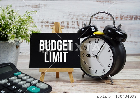Budget Limit text with alarm clock and calculator on wooden background Budget Limit text with alarm clock and calculator on wooden background 130434938