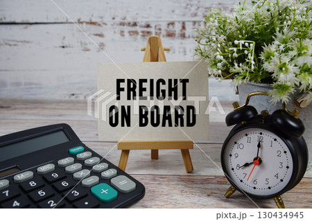FOB Freight on Board text with alarm clock and calculator on wooden background FOB Freight on Board text with alarm clock and calculator on wooden background 130434945
