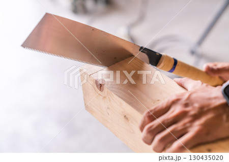 大工がのこぎりで木材を手作業で切る DIY 木工 職人の現場作業風景 130435020