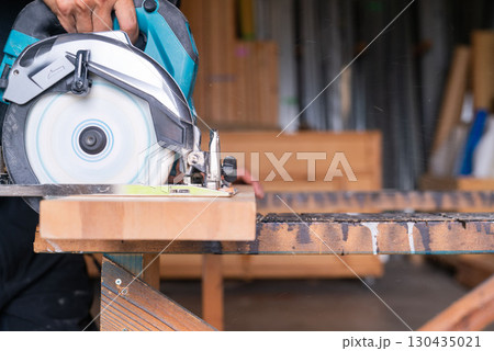 電動丸ノコで木材を切断する大工 木工加工 建築現場 DIY 作業風景 130435021