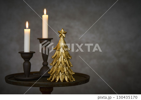 アンティークなサイドテーブルに置かれたクリスマスツリーとキャンドルスタンド アンティークなサイドテーブルに置かれたクリスマスツリーとキャンドルスタンド 130435170