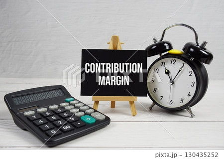 Contribution text with alarm clock and calculator on wooden background 130435252