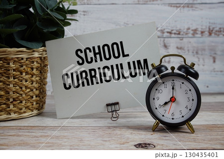 School Curriculum text with alarm clock on wooden background School Curriculum text with alarm clock on wooden background 130435401