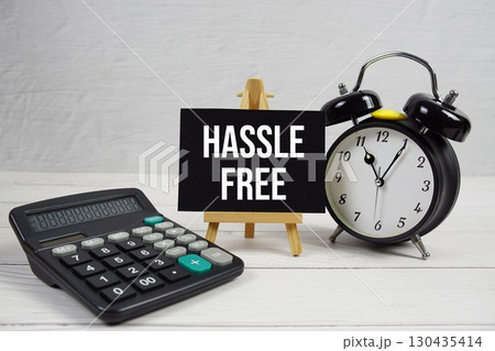 Hassle Free text with alarm clock on wooden background 130435414