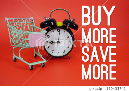 Buy More Save More text with trolley shopping cart and alarm clock on red background Buy More Save More text with trolley shopping cart and alarm clock on red background 130435741