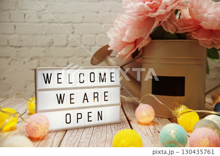 Welcome We are Open text on lightbox on wooden background 130435761