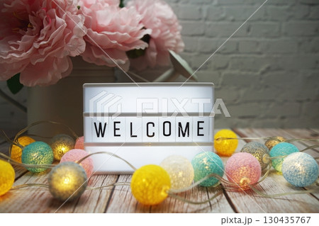 Welcome text on lightbox on wooden background Welcome text on lightbox on wooden background 130435767
