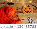 Orange wool and knitting needles with decorative bat. Halloween still life. Cozy lifestyle concept. Autumn lifestyle. October background. Bright needlework and smiling pumpkin. 130435788