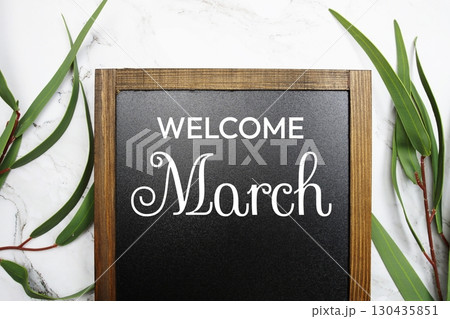 Welcome March text with eucalyptus leaf decorated on marble background Welcome March text with eucalyptus leaf decorated on marble background 130435851