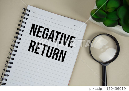 Negative Return text on paper notebook with magnifying glass on beige leather background 130436019
