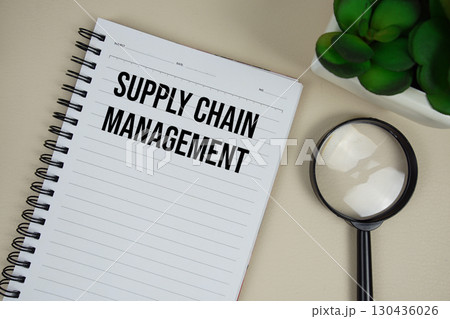 Supply Chain Management (SCM) text on paper notebook with magnifying glass on beige leather background Supply Chain Management (SCM) text on paper notebook with magnifying glass on beige leather background 130436026