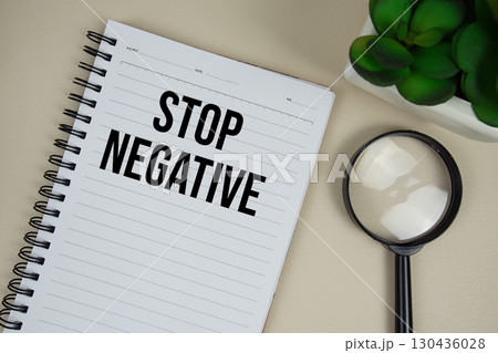 Stop Negative text on paper notebook with magnifying glass on beige leather background Stop Negative text on paper notebook with magnifying glass on beige leather background 130436028